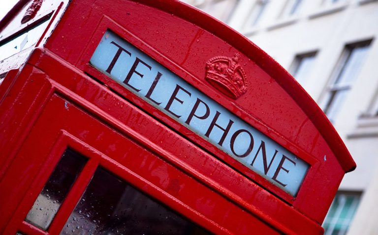Rote englische Telefonzelle mit dem Schriftzug "TELEPHONE" oben und einer Krone.