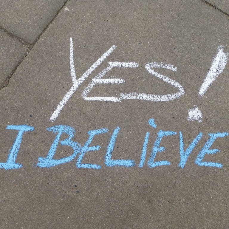 Graffiti auf dem Boden mit den Worten "YES! I BELIEVE".