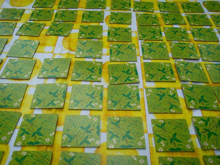 Grüne Memorykarten auf gelber Tischdecke angeordnet.