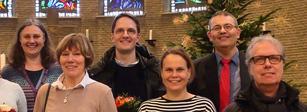 Ev.-luth. Epiphaniengemeinde Hamburg – Kirchengemeinderatsversammlung Gruppe von sechs Menschen steht in einer Kirche.