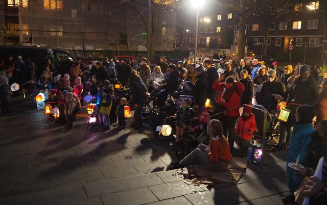 Epiphaniengemeinde Hamburg – Sankt Martin – Laternenumzug Sehr viele Kinder und Erwachsene mit Laternen auf dem Kirchenvorplatz.